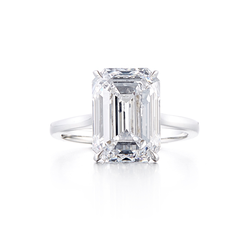 A solitaire style engagement ring with an 18 karat white gold band and a 7.02 carat emerald cut center stone that is a D color and VS1 clarity according to GIA.