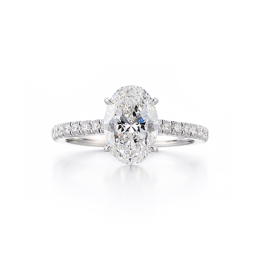 A pave style engagement ring with an 18 karat white gold band and a 2.05 carat oval cut center stone that is an E color and SI1 clarity according to GIA.
