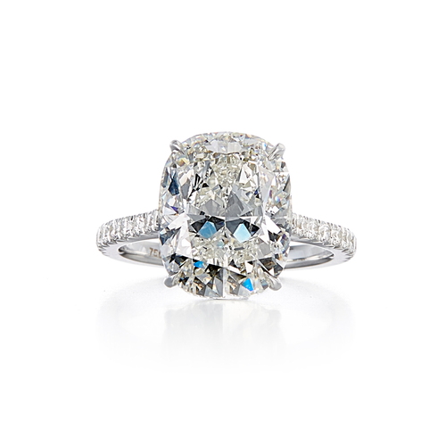 A modern pave style engagement ring with a platinum band and a 7.29 carat cushion cut center stone that is a G color and VS1 clarity according to GIA.
