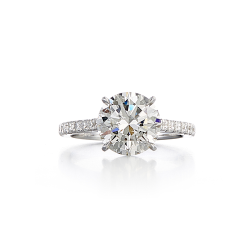 A pave style engagement ring with a 18 karat white gold band and a 3.10 carat round cut center stone that is a G color and SI1 clarity according to GIA.